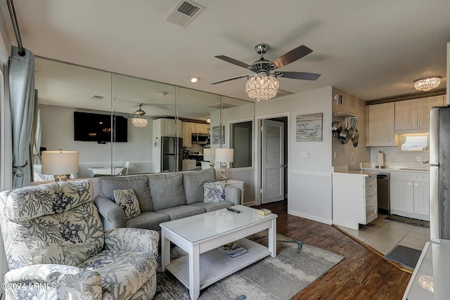 living room featuring ceiling fan and light hardwood / wood-style floors