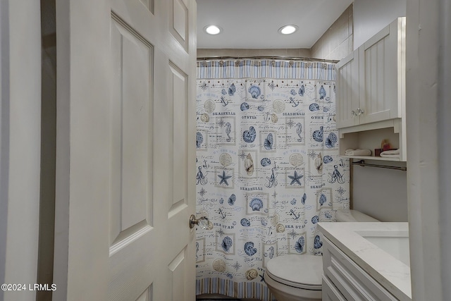 bathroom with vanity, curtained shower, and toilet