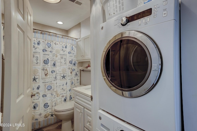 laundry area featuring stacked washing maching and dryer