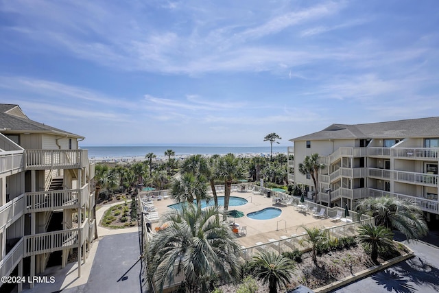 view of swimming pool with a water view and a patio