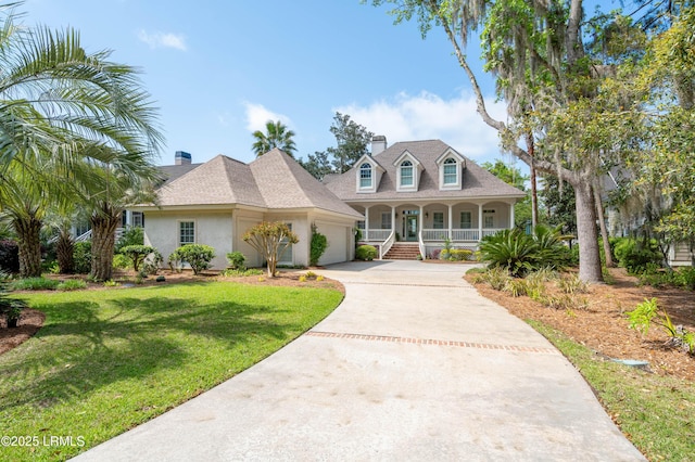 16 Island Creek Dr, Okatie, SC 29909 - cape cod house featuring a porch, a garage, concrete driveway, a front lawn, and stucco siding