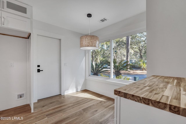 unfurnished dining area featuring visible vents and light wood-style flooring