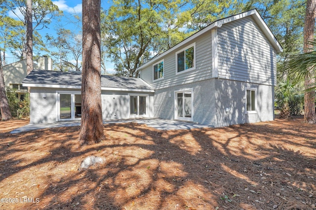 back of property with a patio area and stucco siding