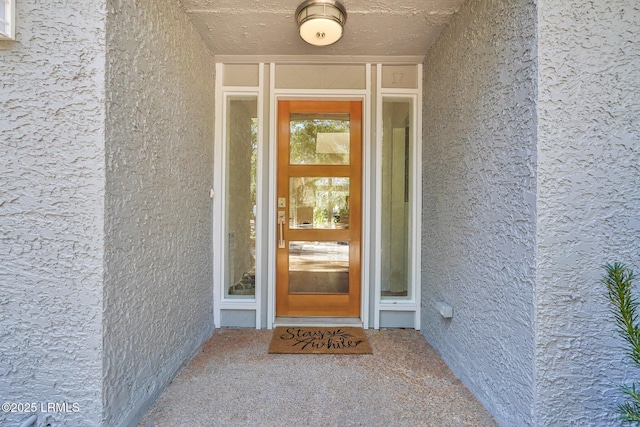 doorway to property featuring stucco siding