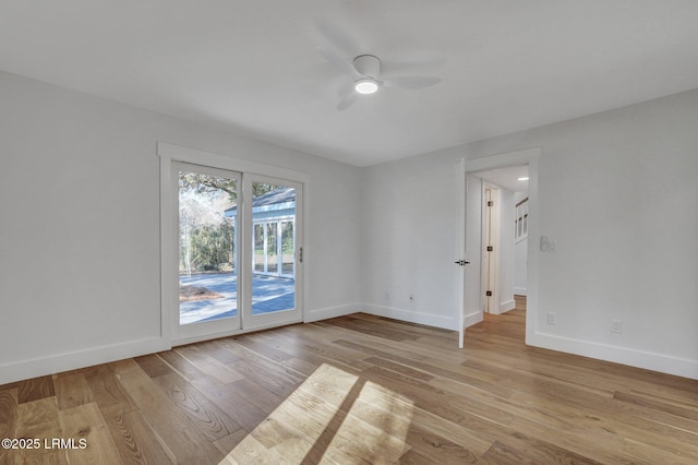 unfurnished room with a ceiling fan, light wood-style floors, and baseboards