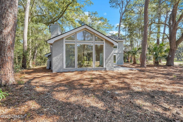 back of property featuring stucco siding and a chimney