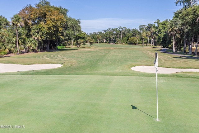 view of property's community featuring a lawn and view of golf course