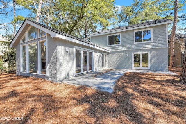 rear view of house with a patio and stucco siding