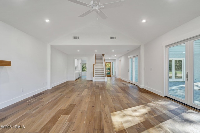 unfurnished living room featuring visible vents, stairs, and vaulted ceiling