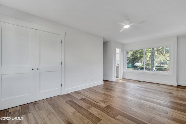 interior space featuring wood finished floors, baseboards, and ceiling fan