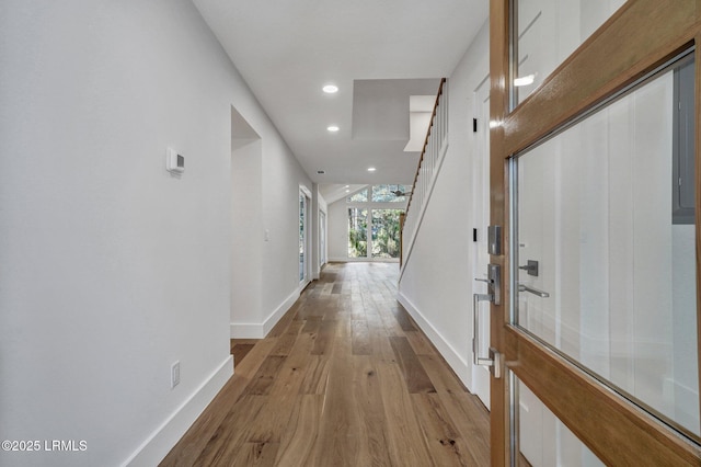 hallway featuring recessed lighting, baseboards, and light wood-style flooring