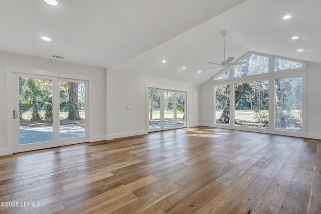 unfurnished living room with visible vents, baseboards, light wood-style floors, and high vaulted ceiling