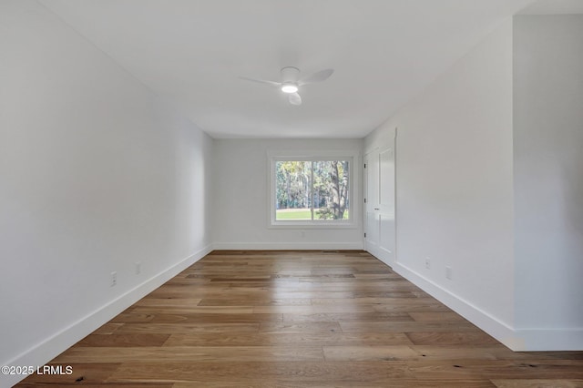 empty room with a ceiling fan, wood finished floors, and baseboards