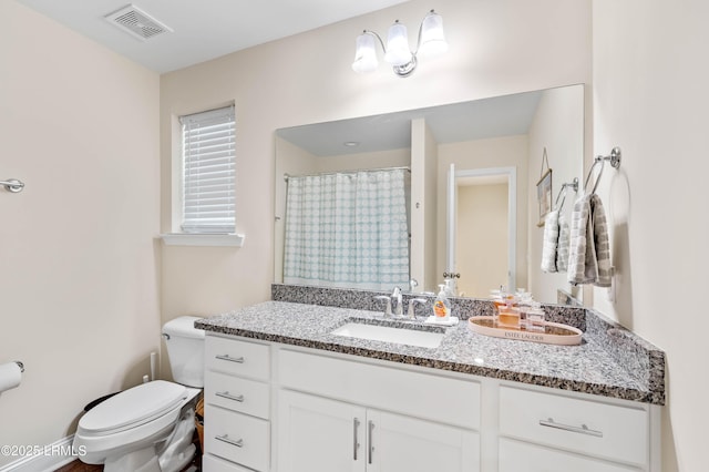 bathroom featuring vanity, toilet, a shower with curtain, and visible vents