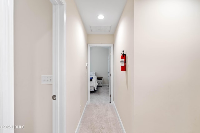 hall with light colored carpet and baseboards