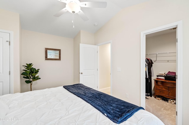 carpeted bedroom with a walk in closet, vaulted ceiling, a closet, and ceiling fan