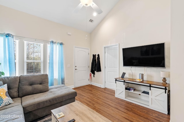 living room with visible vents, high vaulted ceiling, a ceiling fan, wood finished floors, and baseboards