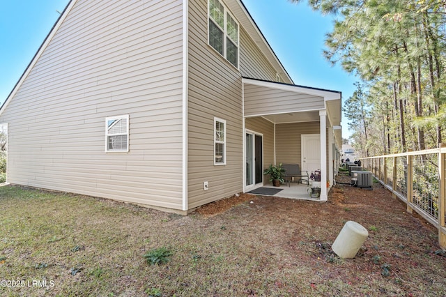 exterior space with a yard, central AC unit, a patio, and fence