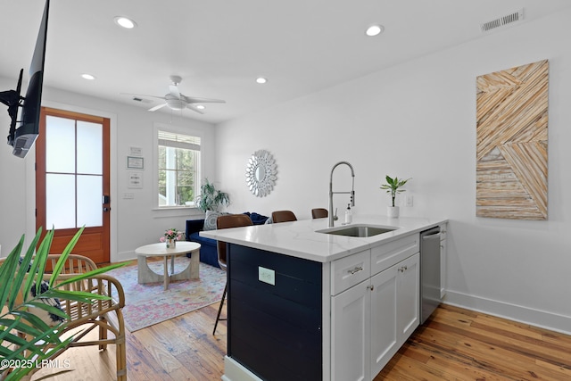 142 President St, Charleston, SC 29403 - kitchen featuring a sink, dishwasher, baseboards, light wood-style flooring, and a peninsula