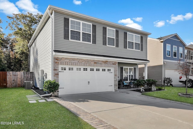 view of front of house with a garage, a front yard, and central AC unit