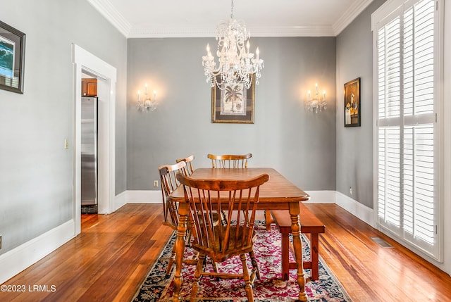 dining room featuring crown molding, a chandelier, and hardwood / wood-style flooring