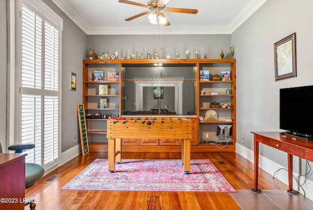 playroom with hardwood / wood-style flooring, ornamental molding, and ceiling fan