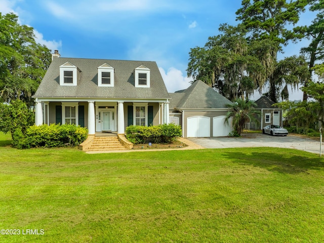 new england style home featuring a garage, a front lawn, and covered porch