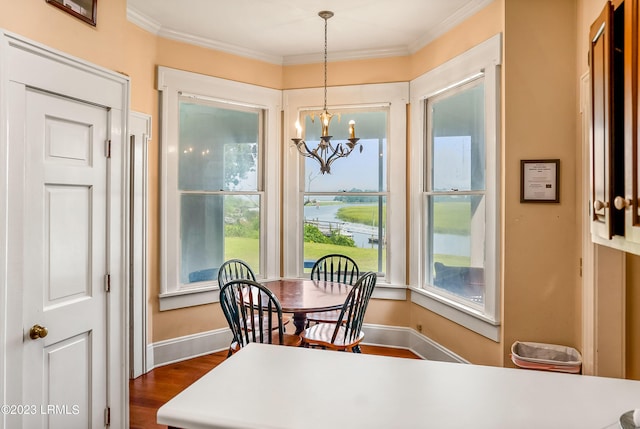 dining room with ornamental molding, dark hardwood / wood-style floors, and a notable chandelier