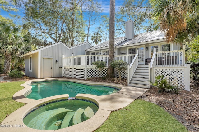 view of swimming pool with a deck, stairway, and a pool with connected hot tub