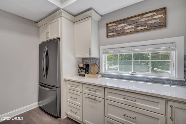 kitchen featuring white cabinets, light countertops, freestanding refrigerator, and dark wood-type flooring