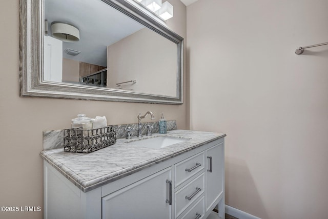 bathroom featuring visible vents, vanity, and baseboards