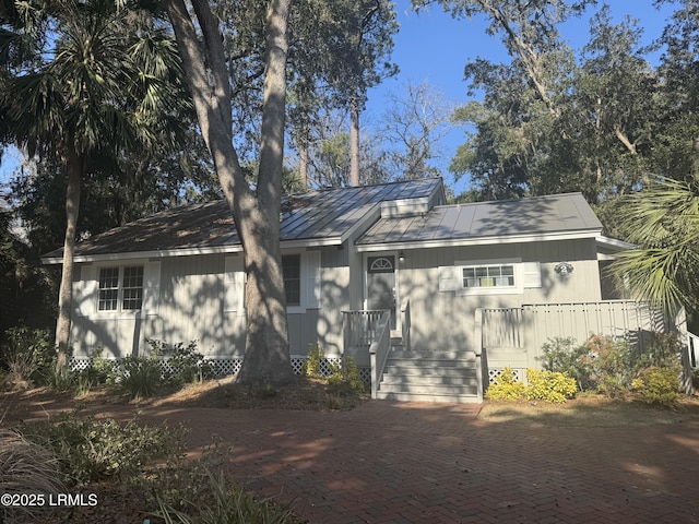 back of house featuring metal roof