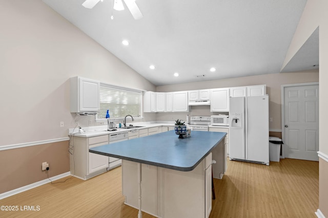 4 Moultrie Ct, Beaufort, SC 29907 - kitchen featuring white appliances, a sink, light wood finished floors, white cabinets, and a kitchen island