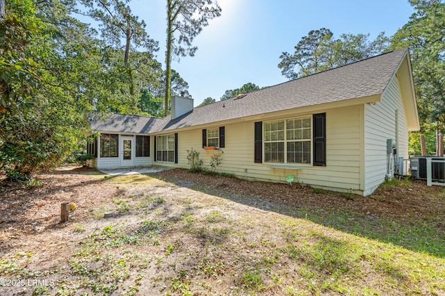 4 Moultrie Ct, Beaufort, SC 29907 - rear view of house with a sunroom, central AC unit, roof with shingles, and a chimney