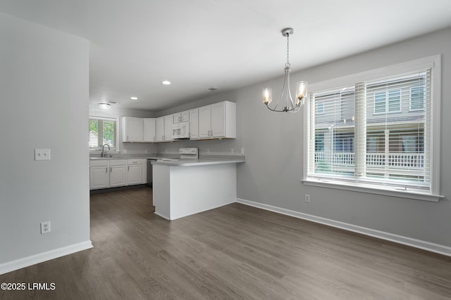 269 Ceasar Pl, Hilton Head Island, SC 29926 - kitchen featuring range, white microwave, a chandelier, white cabinets, and baseboards