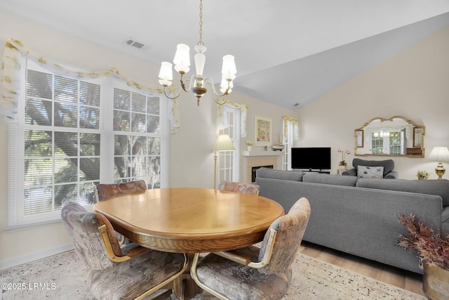 70 Shipyard Dr Unit 166, Hilton Head Island, SC 29928 - dining space featuring a chandelier, light wood finished floors, baseboards, lofted ceiling, and a tile fireplace