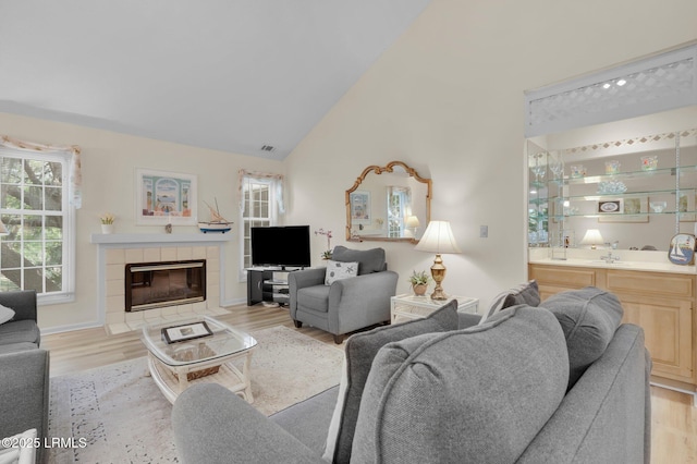 70 Shipyard Dr Unit 166, Hilton Head Island, SC 29928 - living room with light wood-type flooring, a fireplace, wet bar, and high vaulted ceiling