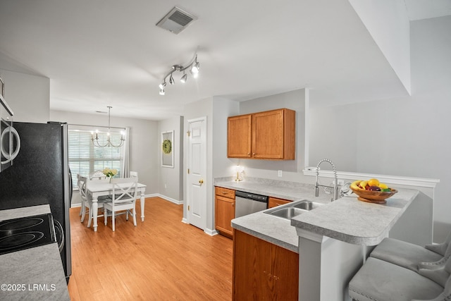 106 Winyah Way, Beaufort, SC 29906 - kitchen with a peninsula, a sink, brown cabinets, and a chandelier