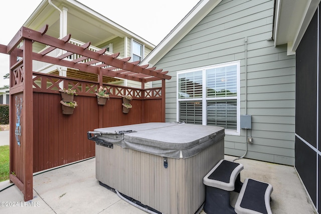 view of patio with a hot tub and a pergola