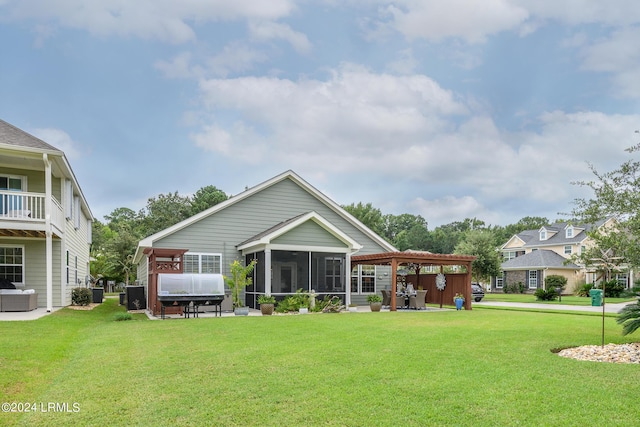 back of house with a pergola, a lawn, and a sunroom