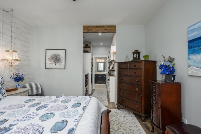 bedroom featuring connected bathroom and light hardwood / wood-style flooring