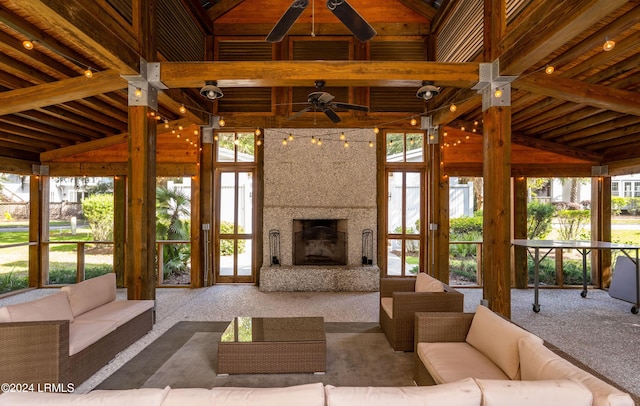 unfurnished living room with ceiling fan, high vaulted ceiling, a premium fireplace, and carpet floors