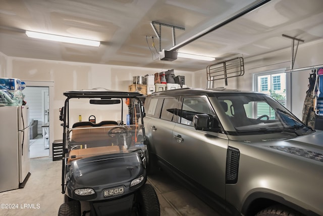 garage with white refrigerator and a garage door opener