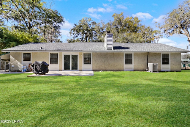 back of property featuring a patio, central air condition unit, a shingled roof, a lawn, and a chimney