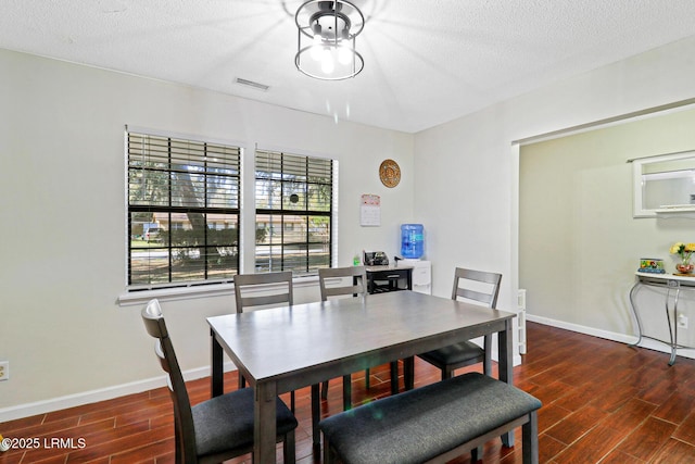 dining space with baseboards, visible vents, and wood finish floors