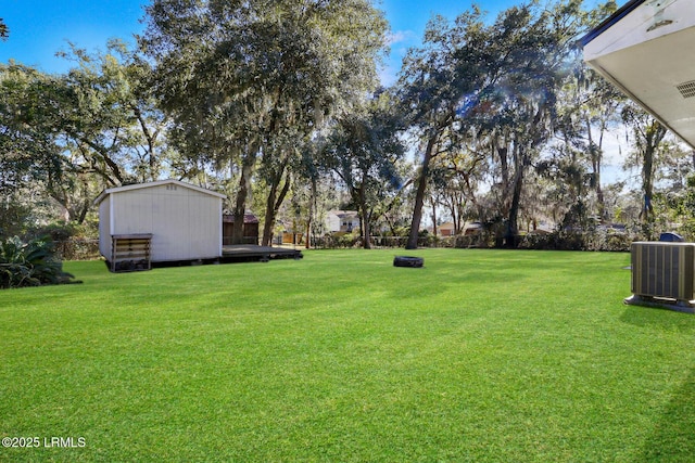 view of yard with an outbuilding, central AC, and a shed