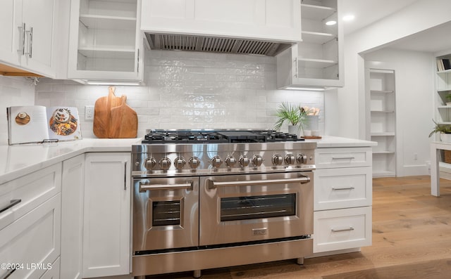 kitchen featuring double oven range, premium range hood, white cabinets, and light hardwood / wood-style floors