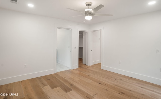 spare room with ceiling fan and light wood-type flooring