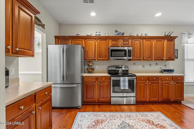 kitchen with hardwood / wood-style floors and stainless steel appliances