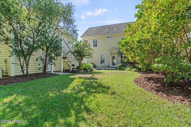 rear view of house featuring a yard